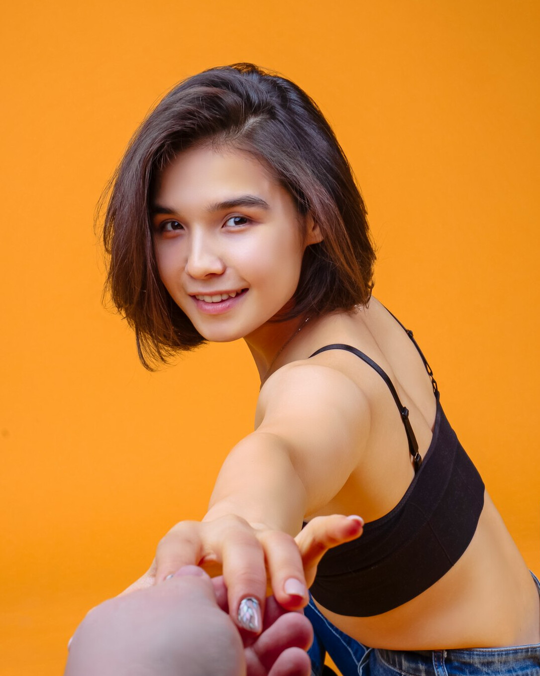 Studio portrait of a smiling woman with short brown hair